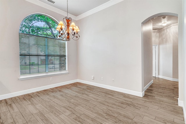 spare room featuring arched walkways, wood finished floors, baseboards, a chandelier, and ornamental molding
