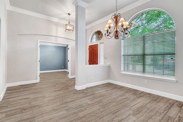 interior space featuring crown molding, baseboards, a chandelier, and wood finished floors