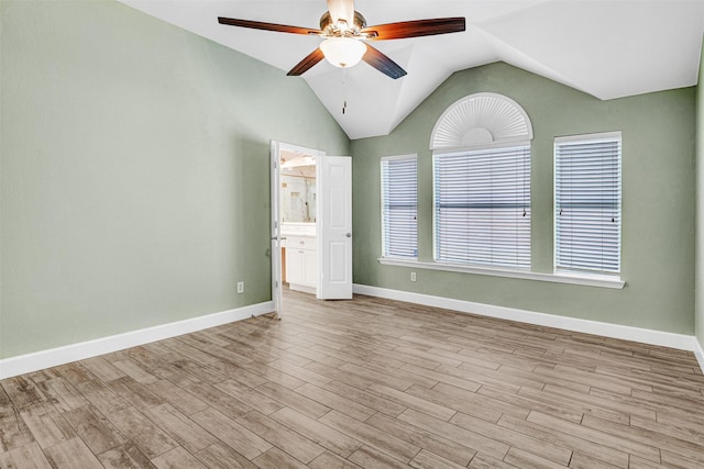 spare room featuring baseboards, a ceiling fan, lofted ceiling, and wood finished floors