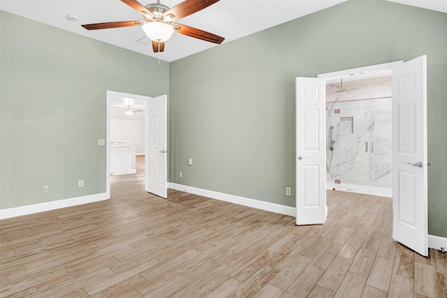 unfurnished bedroom with baseboards, light wood-style flooring, and lofted ceiling