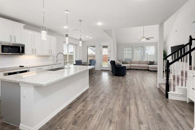 5604 Deer Run Dr, Celina, TX 75009 - kitchen featuring ceiling fan, a sink, white cabinetry, stainless steel microwave, and wood finished floors