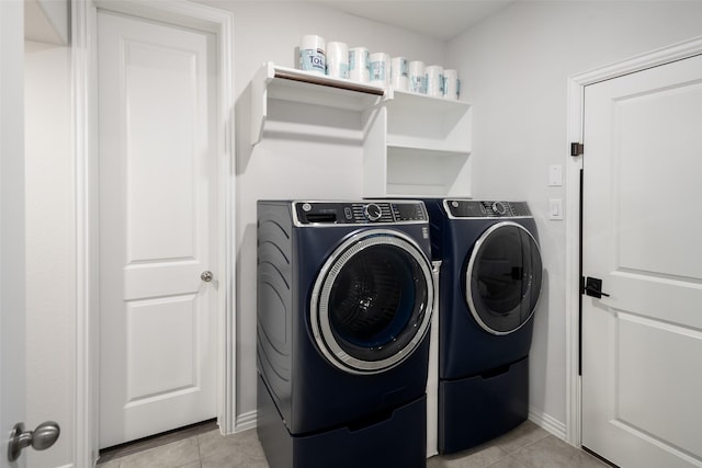 laundry area with laundry area, baseboards, light tile patterned floors, and separate washer and dryer
