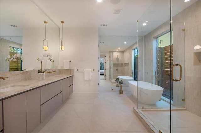 bathroom with visible vents, a sink, a freestanding bath, and a stall shower