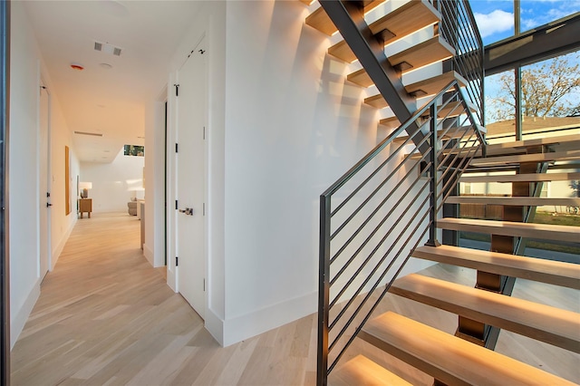 stairway with visible vents and wood finished floors
