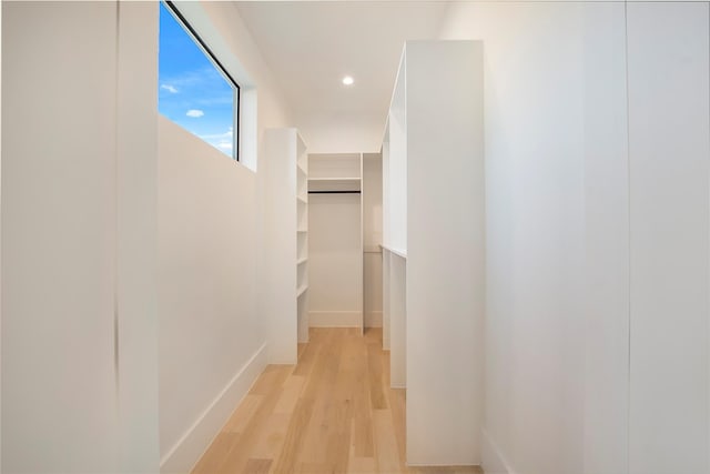 hallway featuring light wood-style floors, recessed lighting, and baseboards