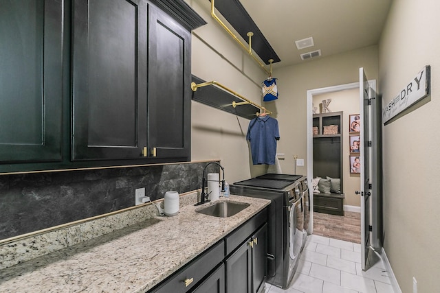 126 Esther Ct, Millsap, TX 76066 - washroom with washing machine and clothes dryer, cabinet space, a sink, light tile patterned floors, and visible vents