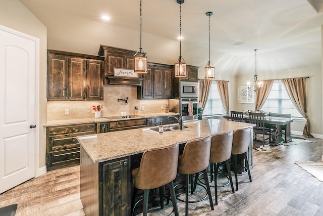 126 Esther Ct, Millsap, TX 76066 - kitchen featuring a breakfast bar, a sink, a chandelier, stainless steel appliances, and a center island with sink