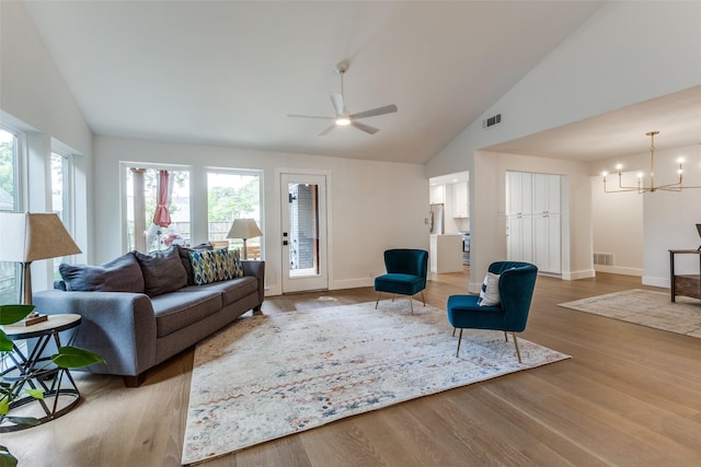 living room with baseboards, ceiling fan with notable chandelier, wood finished floors, and visible vents