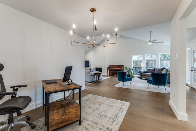 interior space featuring baseboards, ceiling fan with notable chandelier, wood finished floors, and high vaulted ceiling