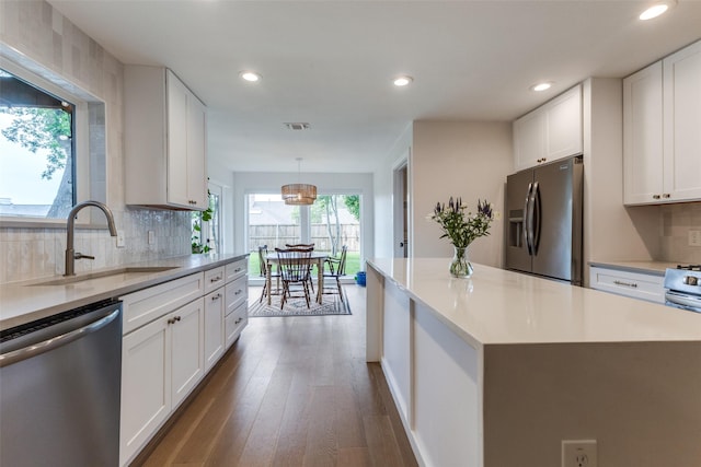 kitchen featuring white cabinets, a sink, light countertops, stainless steel appliances, and recessed lighting