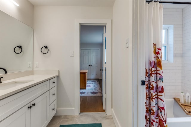 bathroom featuring vanity, baseboards, and tile patterned flooring