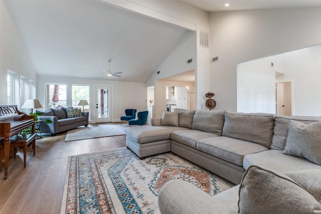 living room featuring visible vents, a ceiling fan, wood finished floors, and high vaulted ceiling