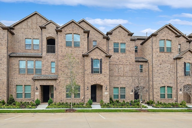 view of front of property with brick siding and uncovered parking