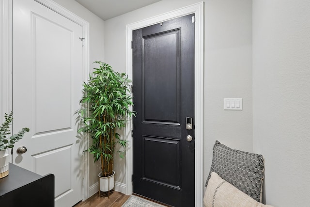 doorway featuring wood finished floors and baseboards