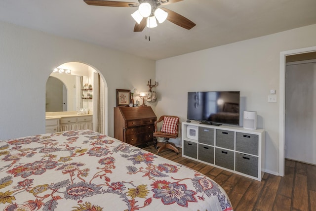 bedroom featuring arched walkways, a ceiling fan, wood finished floors, and ensuite bathroom