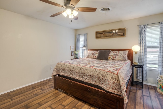 bedroom featuring visible vents, baseboards, dark wood-type flooring, and ceiling fan