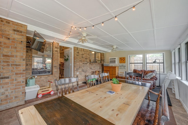 dining space featuring brick wall, a wall unit AC, and ceiling fan