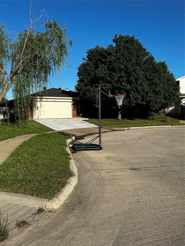 exterior space with concrete driveway and a front yard