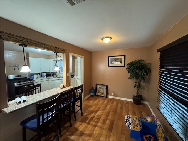 dining room with baseboards, wood finished floors, and visible vents