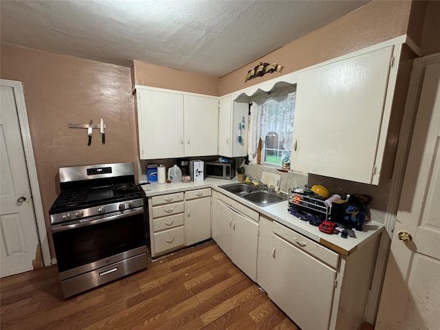 kitchen featuring light countertops, stainless steel appliances, white cabinets, and wood finished floors