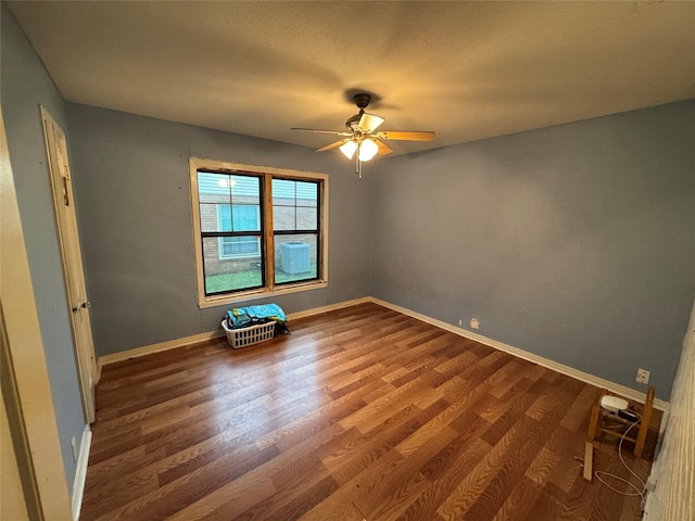 empty room with a ceiling fan, baseboards, and wood finished floors