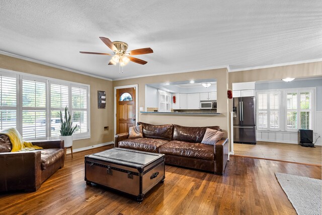 living room with ceiling fan, plenty of natural light, baseboards, and hardwood / wood-style flooring