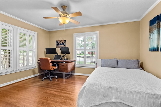 bedroom featuring crown molding, baseboards, ceiling fan, and wood finished floors