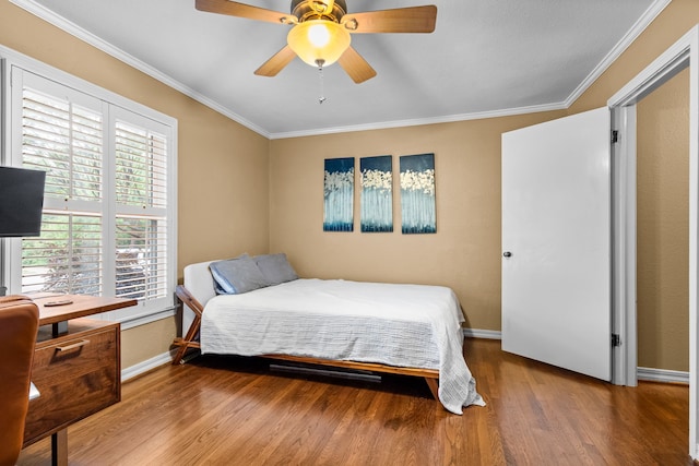 bedroom featuring baseboards, ornamental molding, a ceiling fan, and wood finished floors