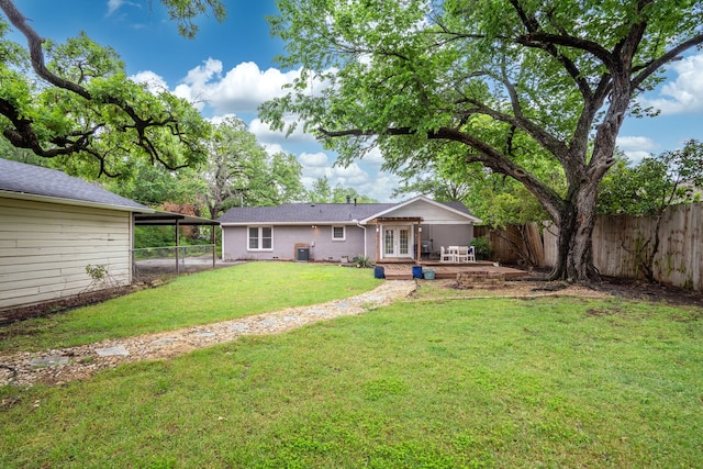 view of yard with a fenced backyard, a patio area, french doors, and an attached carport