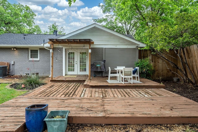 back of house with brick siding, a deck, fence, and a pergola