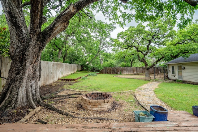 view of yard featuring a fenced backyard and a fire pit