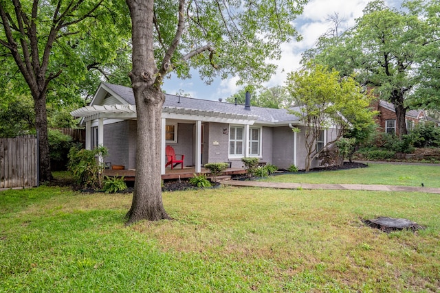 ranch-style house featuring a wooden deck, fence, a pergola, a front yard, and brick siding