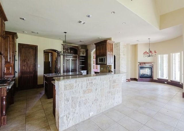 kitchen featuring visible vents, built in appliances, light tile patterned floors, and a chandelier