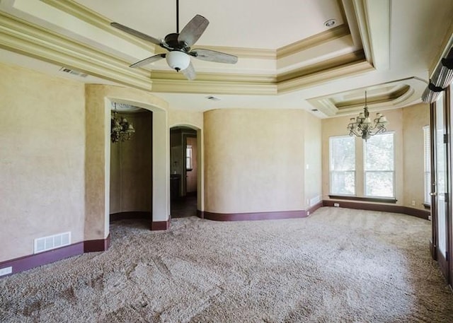 spare room with crown molding, arched walkways, carpet flooring, and visible vents