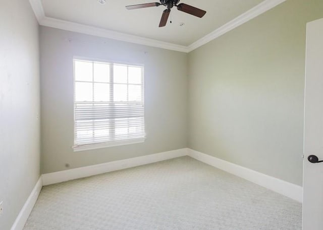 carpeted empty room with plenty of natural light, ornamental molding, baseboards, and a ceiling fan
