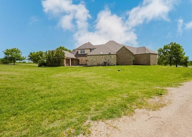 view of side of property with a yard and stone siding