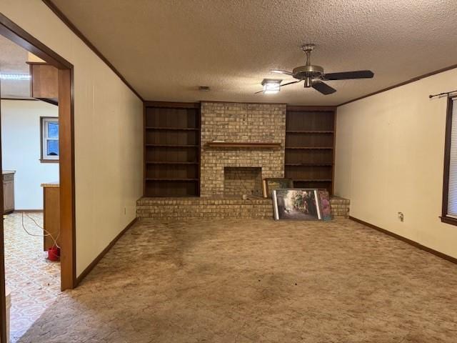 unfurnished living room featuring carpet floors, ceiling fan, a fireplace, and a textured ceiling