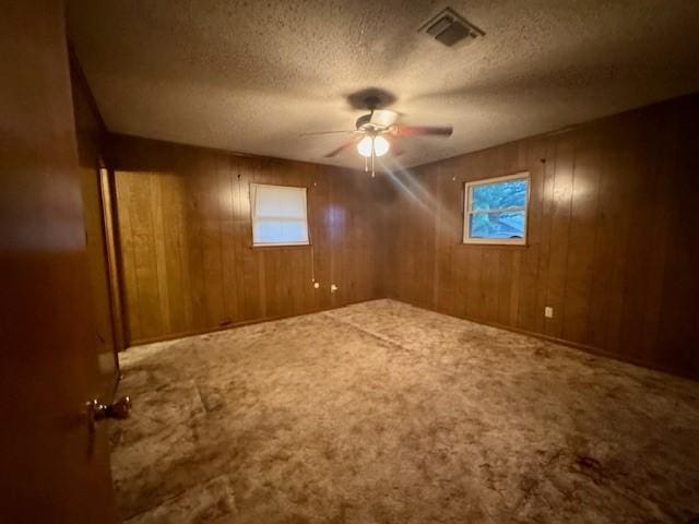 bonus room featuring a textured ceiling, ceiling fan, visible vents, and a wealth of natural light