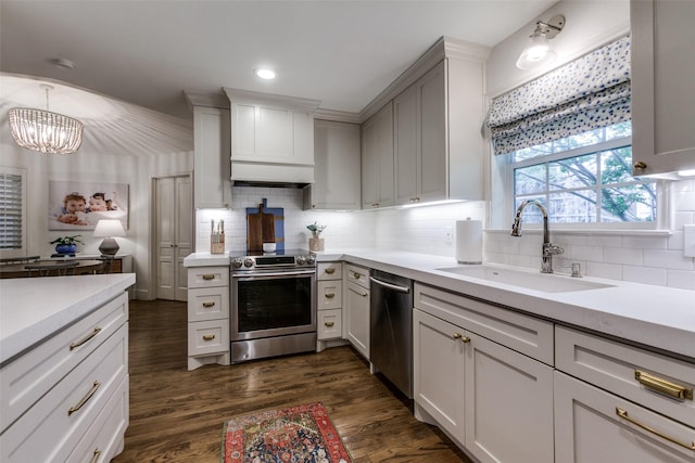 kitchen featuring light countertops, a sink, a notable chandelier, and stainless steel appliances