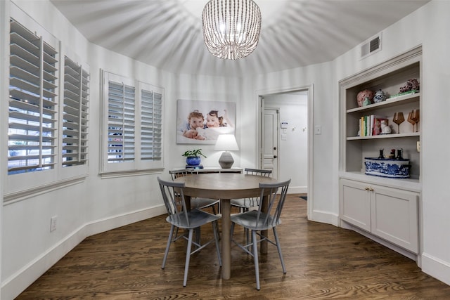 dining area with baseboards, visible vents, dark wood finished floors, and a notable chandelier