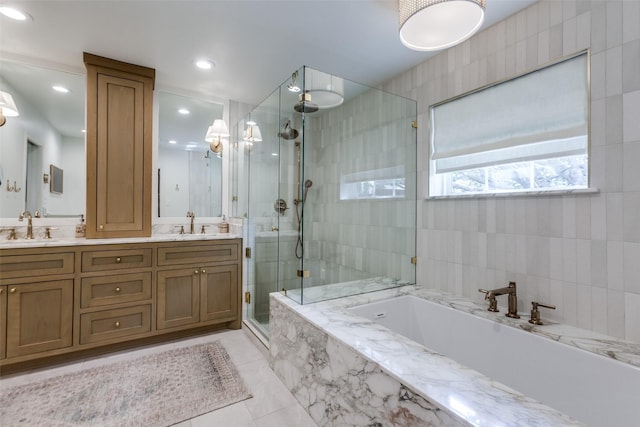 bathroom featuring a sink, double vanity, a shower stall, and a garden tub