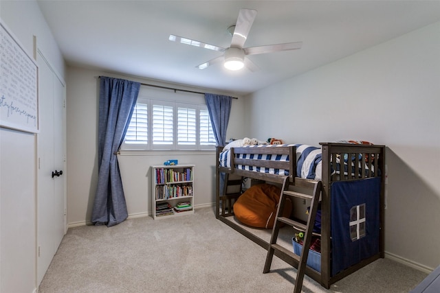 carpeted bedroom featuring baseboards and a ceiling fan