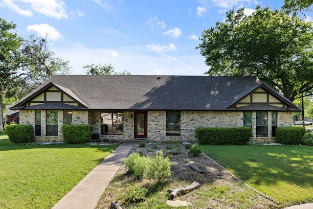 english style home with brick siding, a shingled roof, and a front lawn