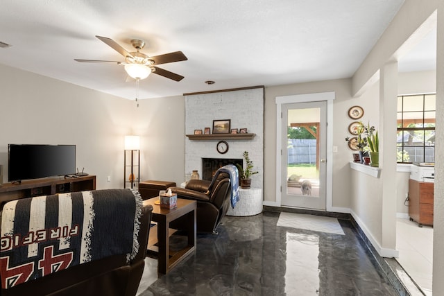 living area with a fireplace, a ceiling fan, baseboards, finished concrete floors, and visible vents