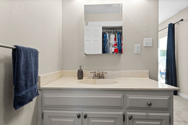 bathroom featuring vanity and a textured wall