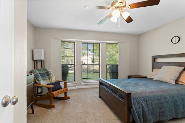 bedroom with a ceiling fan and light colored carpet