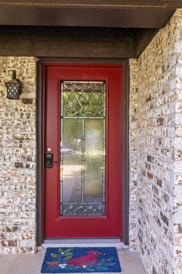 view of exterior entry featuring brick siding