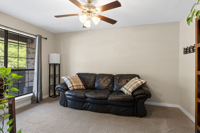 living area featuring baseboards, carpet flooring, and ceiling fan