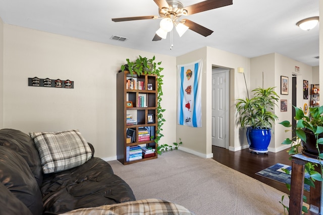 living area featuring carpet flooring, a ceiling fan, baseboards, and visible vents