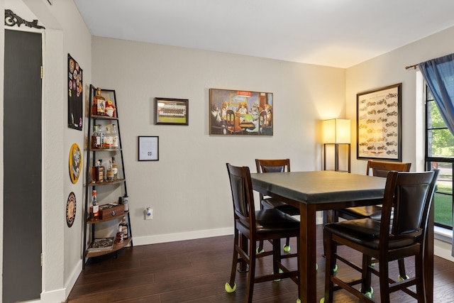 dining area with baseboards and dark wood finished floors